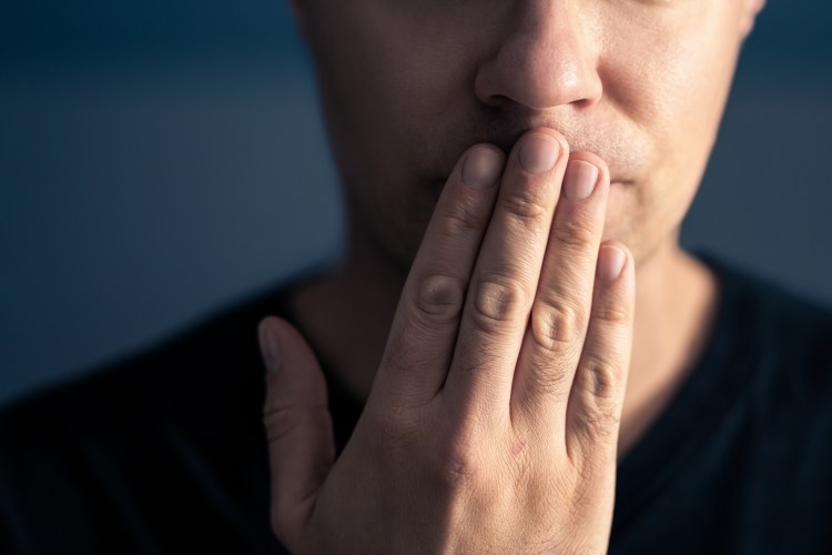 hand covers mouth, silence or secrecy